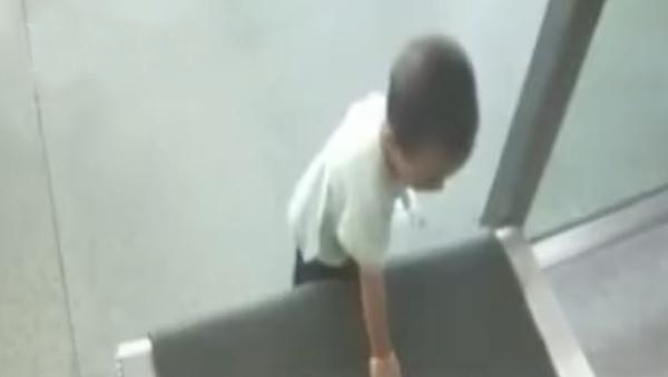 小孩用手摸安檢機(jī)傳送帶